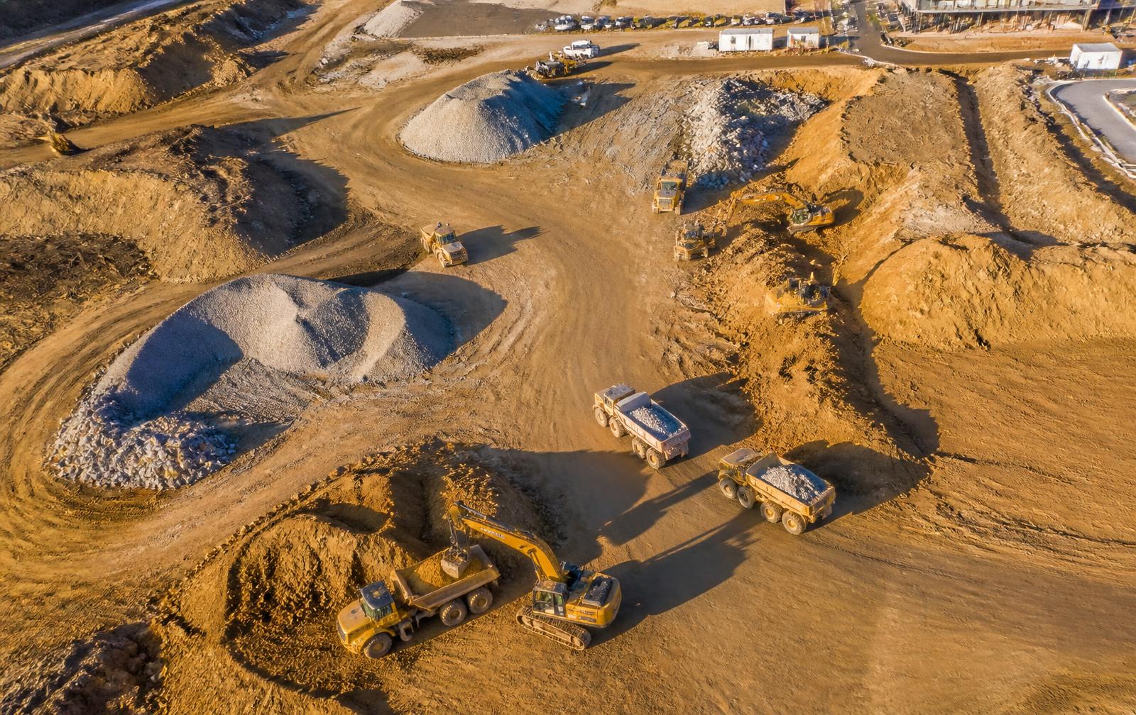 Aerial view of earthworks site with stockpiles being measured